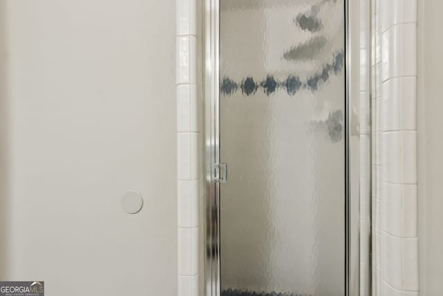 bathroom featuring a shower with door