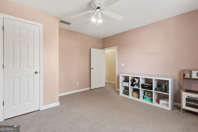 interior space featuring light colored carpet and ceiling fan