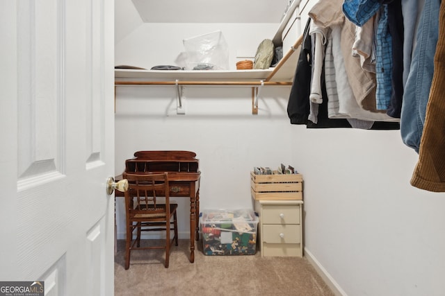 walk in closet featuring light colored carpet