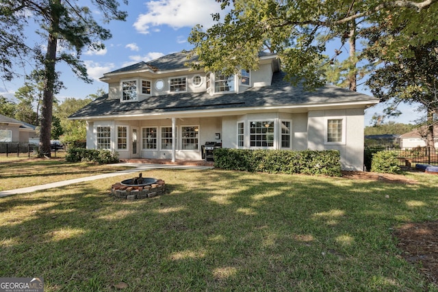 view of front of property with a front yard, an outdoor fire pit, and a patio area