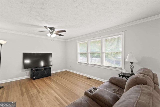 living room featuring ornamental molding, hardwood / wood-style floors, a textured ceiling, and ceiling fan