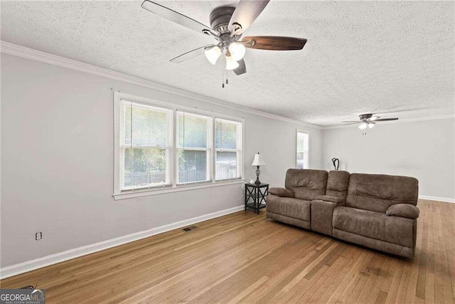 living room featuring crown molding, hardwood / wood-style flooring, a textured ceiling, and ceiling fan