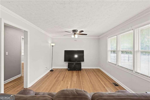 unfurnished living room featuring hardwood / wood-style flooring, crown molding, ceiling fan, and a textured ceiling