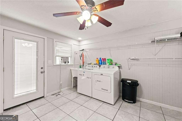 washroom featuring independent washer and dryer, wood walls, light tile patterned floors, and ceiling fan