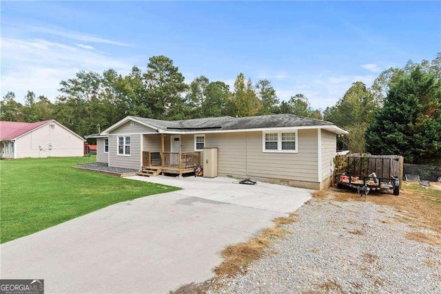 ranch-style home with a wooden deck and a front lawn