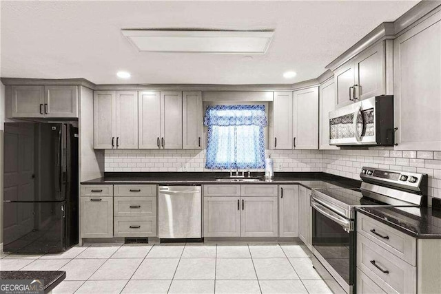 kitchen with light tile patterned floors, gray cabinets, sink, and stainless steel appliances