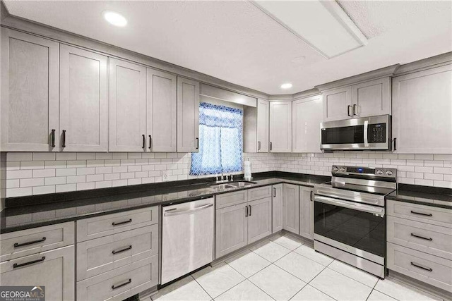 kitchen featuring stainless steel appliances, gray cabinetry, sink, and light tile patterned floors