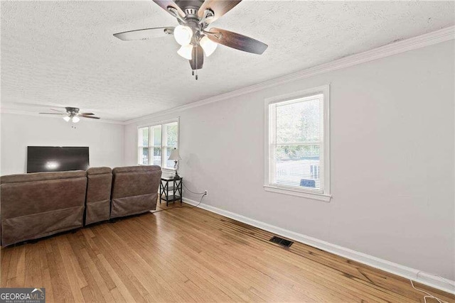 living room featuring wood-type flooring, a textured ceiling, and a healthy amount of sunlight