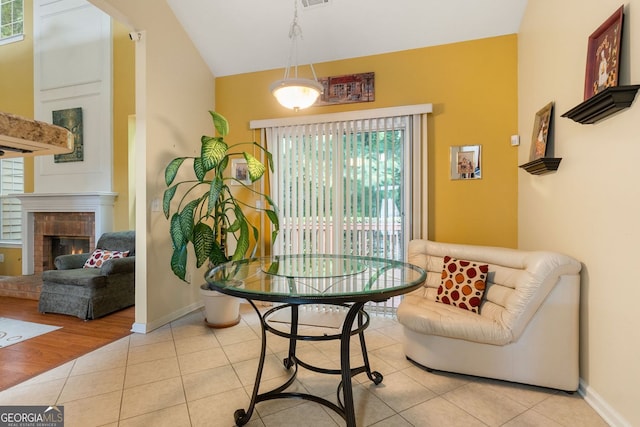 dining space featuring a fireplace, light wood-type flooring, and a wealth of natural light