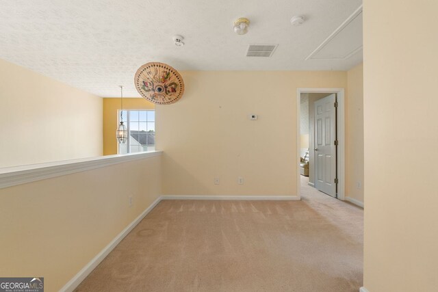 carpeted spare room featuring a textured ceiling