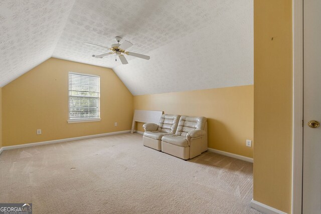 bonus room featuring lofted ceiling, ceiling fan, light carpet, and a textured ceiling