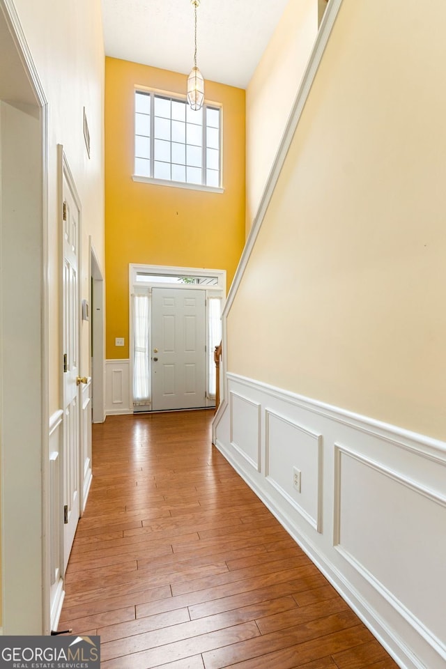 foyer entrance featuring a towering ceiling and hardwood / wood-style floors