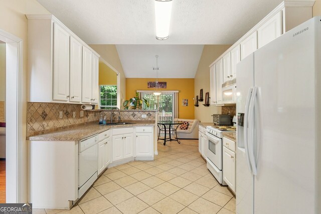 kitchen featuring lofted ceiling, white appliances, and white cabinets