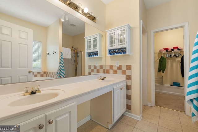 bathroom with tile patterned flooring, walk in shower, and vanity