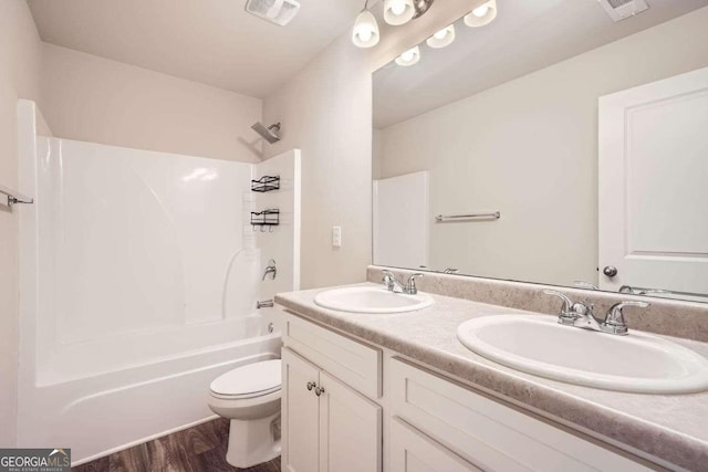 full bathroom with hardwood / wood-style flooring, bathtub / shower combination, vanity, and toilet