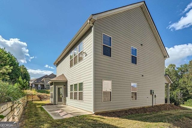 rear view of house featuring a lawn and a patio area