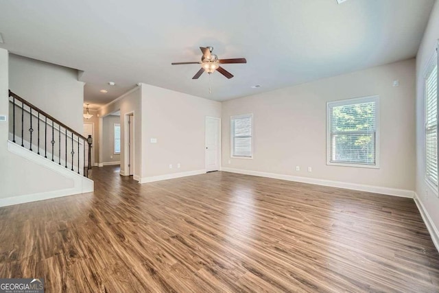 unfurnished living room featuring ceiling fan and dark hardwood / wood-style flooring