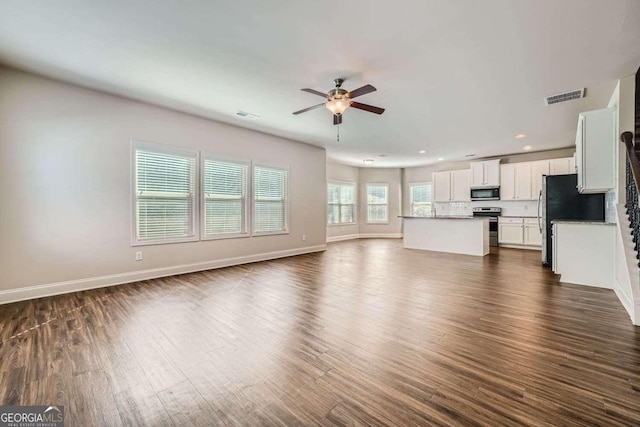 unfurnished living room featuring ceiling fan and dark hardwood / wood-style floors