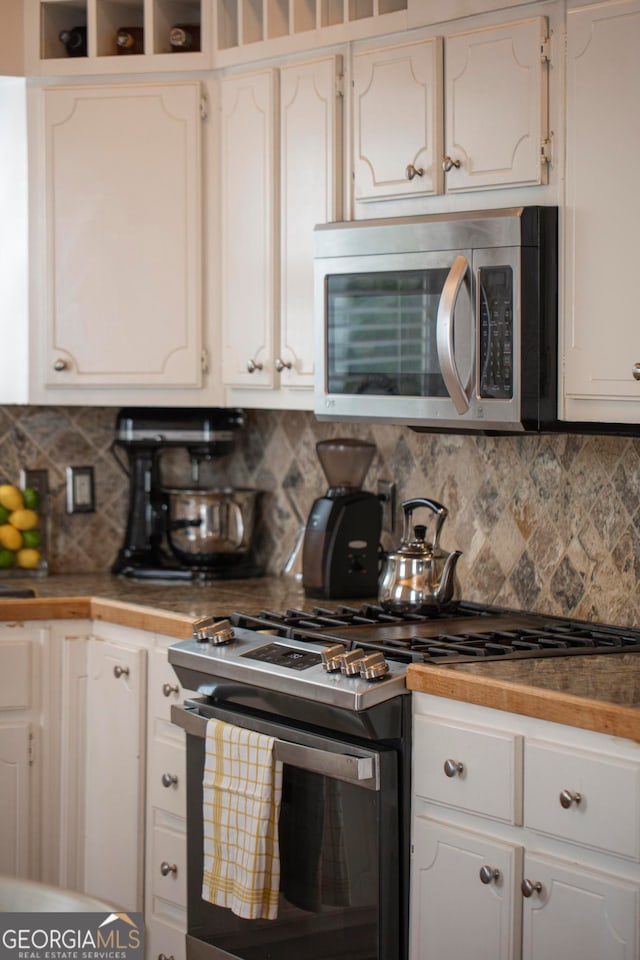 kitchen featuring white cabinetry, backsplash, and appliances with stainless steel finishes