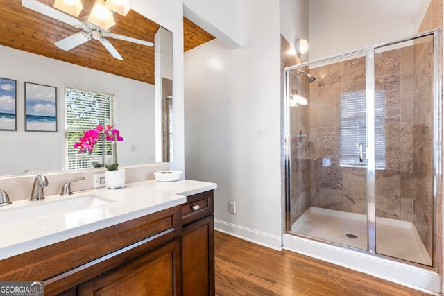 bathroom featuring a shower with shower door, wooden ceiling, hardwood / wood-style floors, vanity, and ceiling fan