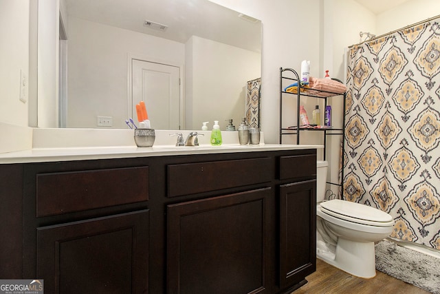 bathroom featuring hardwood / wood-style floors, a shower with shower curtain, vanity, and toilet