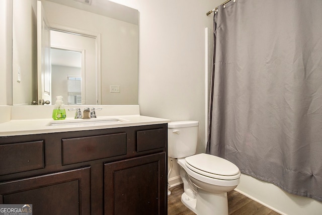 full bathroom featuring shower / bathtub combination with curtain, hardwood / wood-style flooring, vanity, and toilet