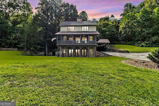 back house at dusk featuring a yard