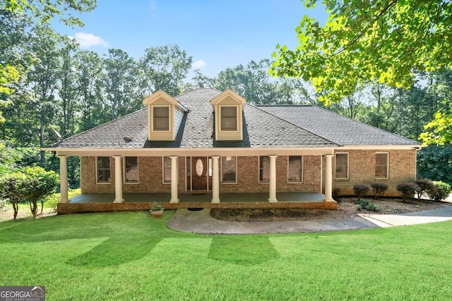 cape cod-style house with a front yard and covered porch