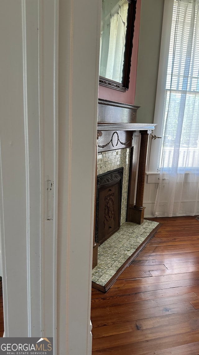 interior details featuring a tile fireplace and hardwood / wood-style floors