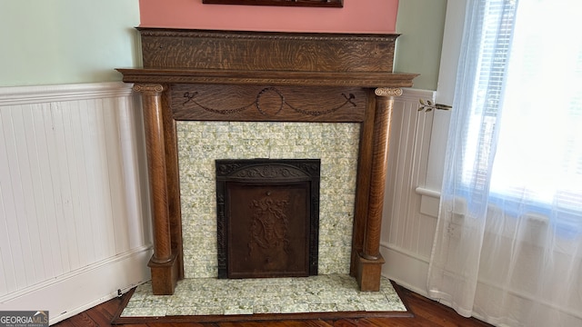 room details with hardwood / wood-style flooring and a tiled fireplace