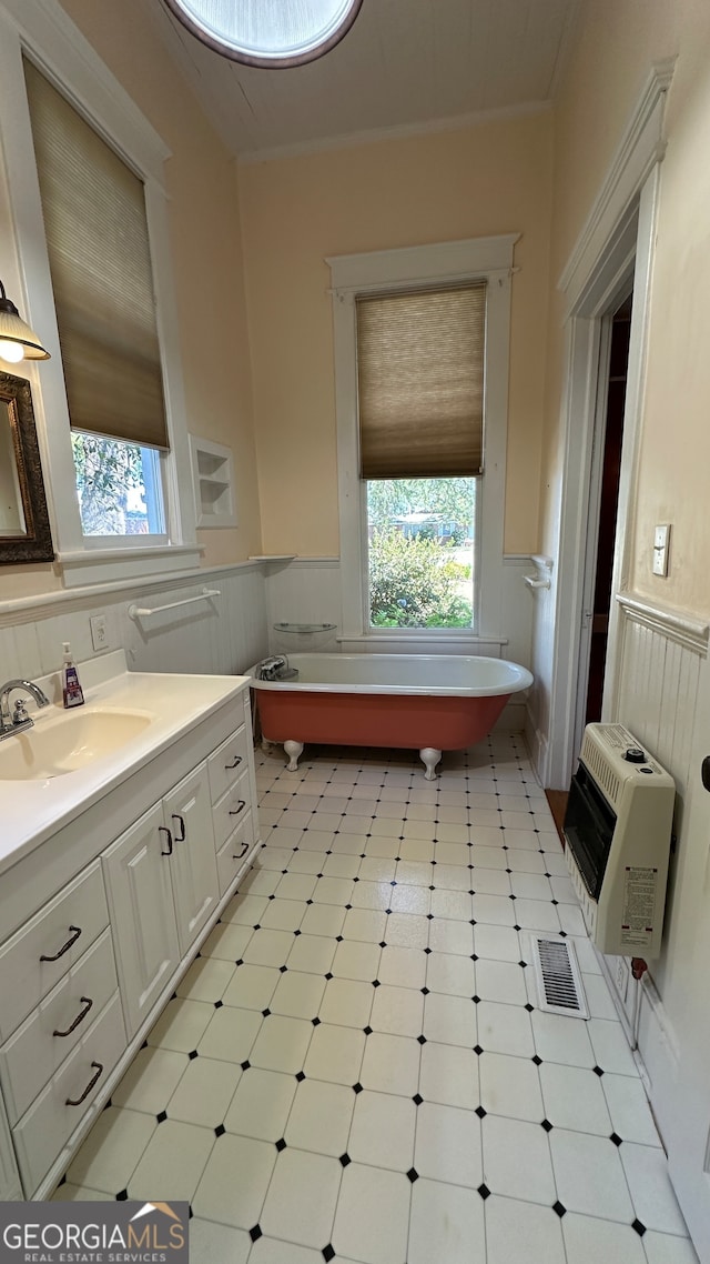 bathroom featuring vanity, heating unit, and a bath