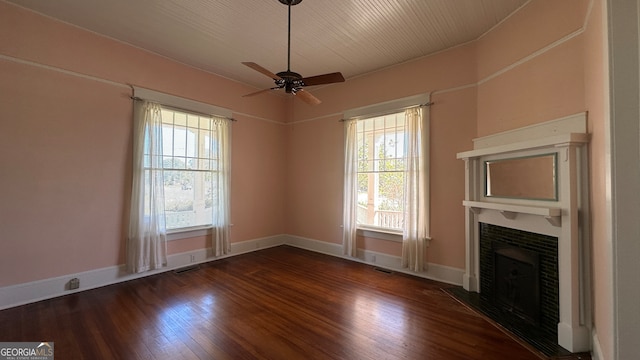 unfurnished living room with dark wood-type flooring, ceiling fan, and plenty of natural light