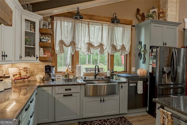 kitchen with black dishwasher, sink, and white cabinetry