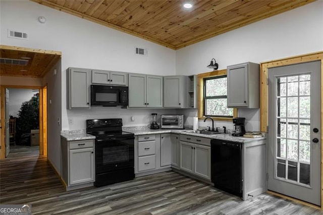 kitchen featuring gray cabinetry, black appliances, and plenty of natural light