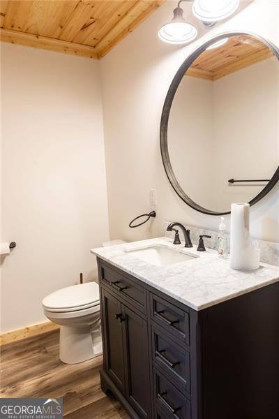 bathroom with vanity, toilet, wooden ceiling, and wood-type flooring