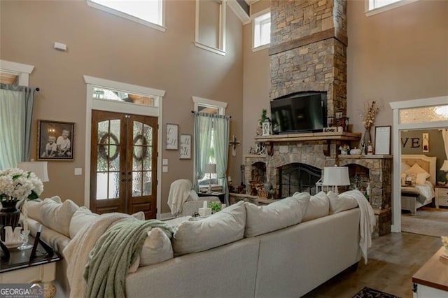 living room featuring a wealth of natural light, french doors, and a towering ceiling