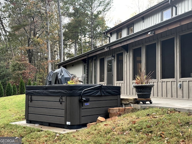 view of property exterior with a hot tub and a yard