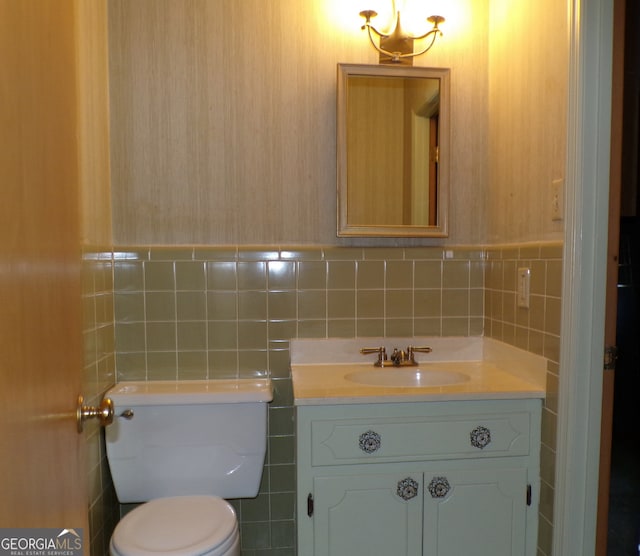 bathroom featuring vanity, tile walls, and toilet