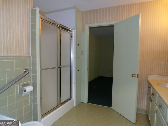 bathroom with walk in shower, vanity, and tile patterned flooring