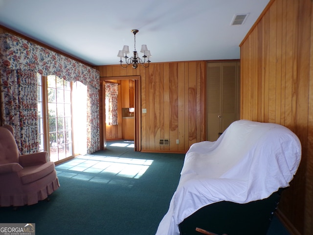 sitting room with light colored carpet, an inviting chandelier, and wooden walls