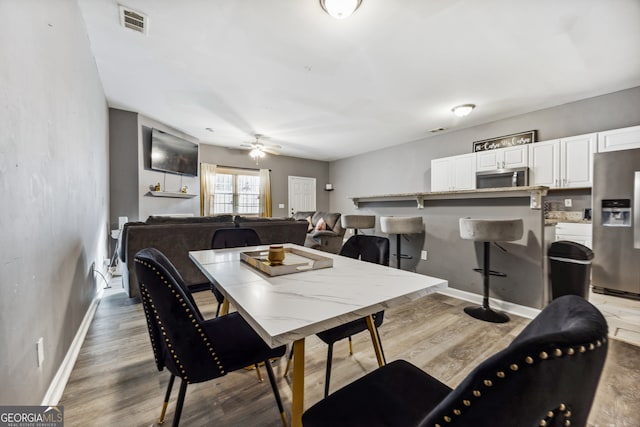 dining area with hardwood / wood-style flooring and ceiling fan