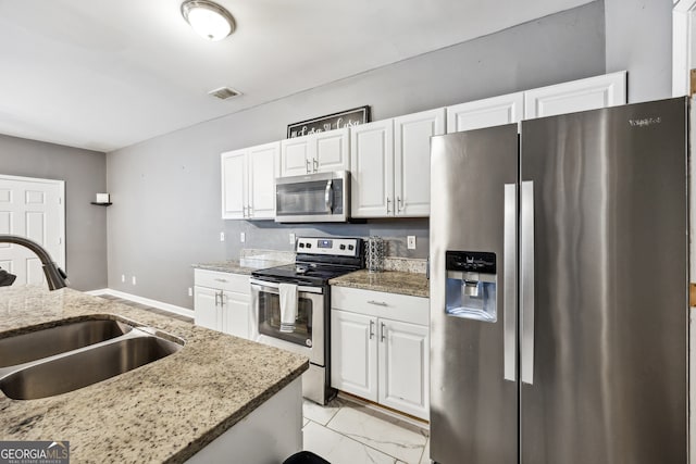 kitchen featuring stainless steel appliances, light stone countertops, sink, and white cabinetry