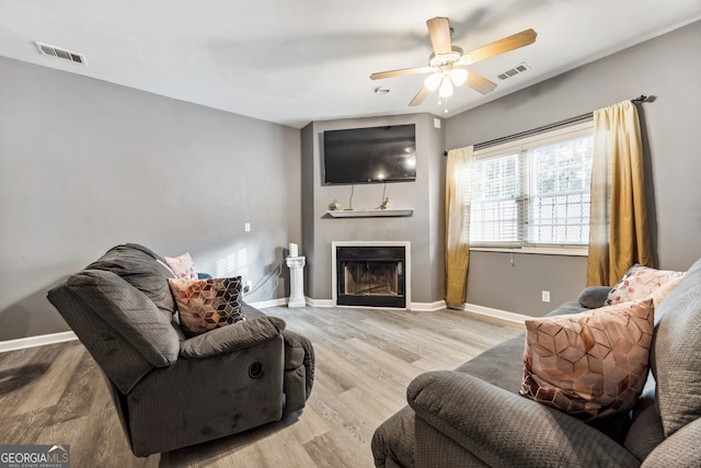 living room with light hardwood / wood-style floors and ceiling fan