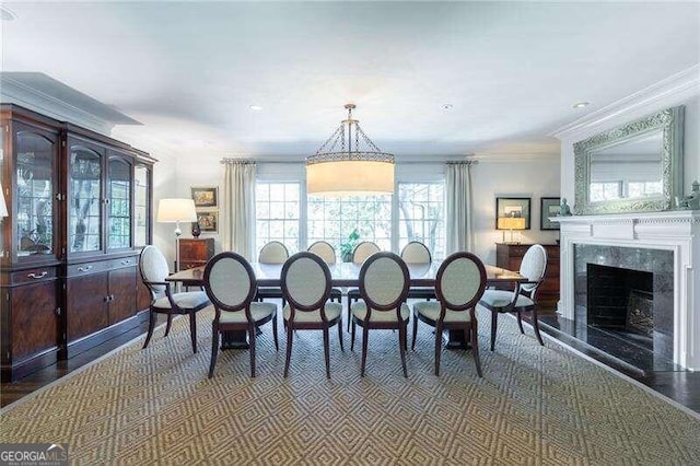 dining area with a fireplace and crown molding