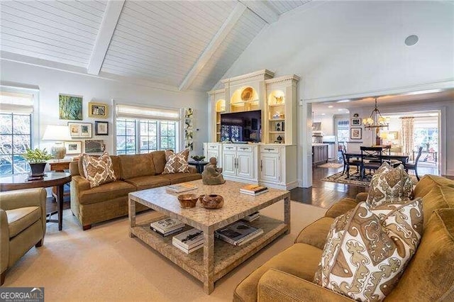 living room featuring beam ceiling, a wealth of natural light, and light hardwood / wood-style floors