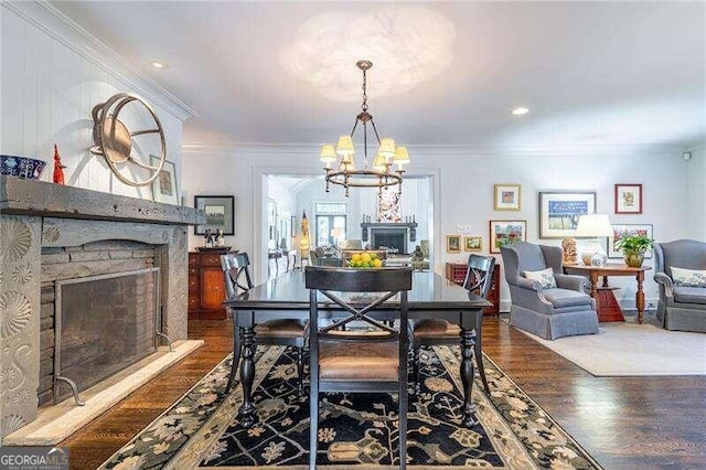 dining room with a fireplace, a notable chandelier, dark hardwood / wood-style floors, and ornamental molding