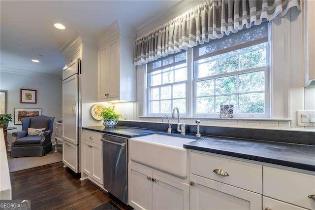 kitchen featuring white cabinets, sink, ornamental molding, stainless steel appliances, and dark hardwood / wood-style flooring