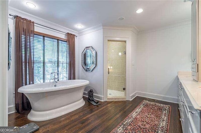 bathroom featuring ornamental molding, hardwood / wood-style flooring, vanity, and independent shower and bath