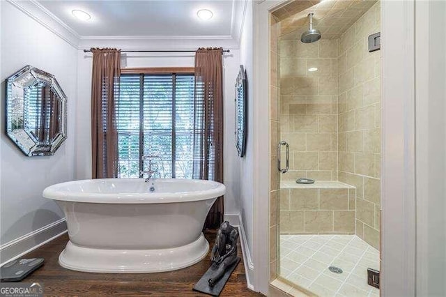 bathroom with crown molding and shower with separate bathtub