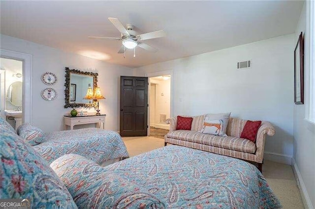 bedroom with ceiling fan, connected bathroom, and light carpet